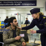 A man holding an identification document while speaking with a Swedish police officer at Stockholm Arlanda Airport regarding asylum in Sweden at the airport.