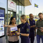 Digital information kiosk displaying safe and legal migration pathways to Sweden 2026 with an officer guiding a group of people in front of the Swedish Migration Agency.