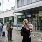 An editorial photo documenting the recent Sweden asylum system changes outside the Swedish Migration Agency building.