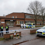 Fagersta school attack investigation outside a Swedish school with police vehicles and a memorial