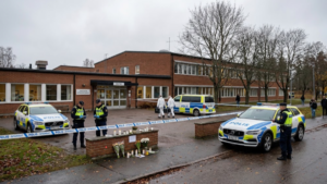 Fagersta school attack investigation outside a Swedish school with police vehicles and a memorial