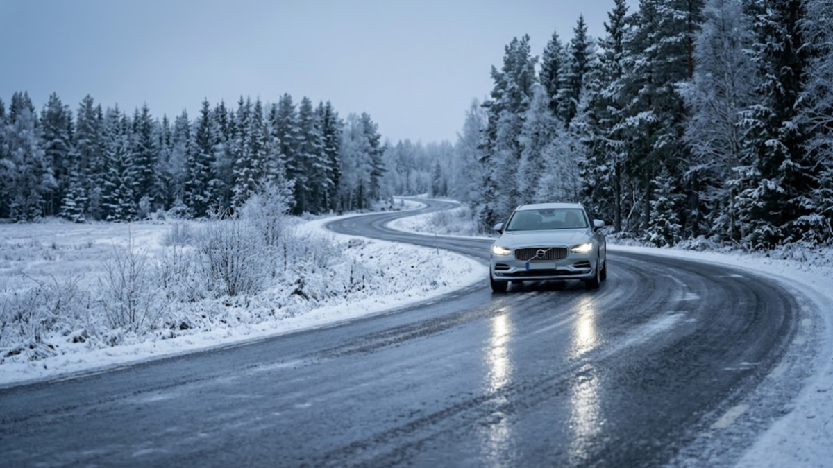 Black ice covering a winter road in Sweden as a car approaches cautiously.